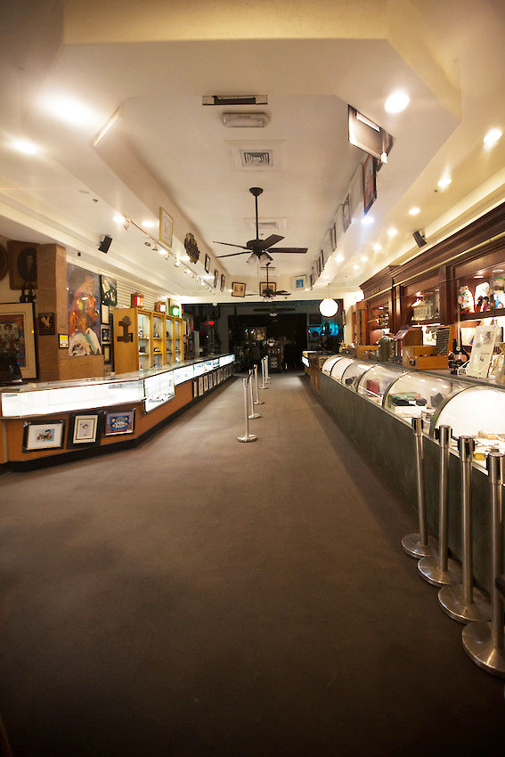 A view from inside a pawn shop with brown shelves and silver counters