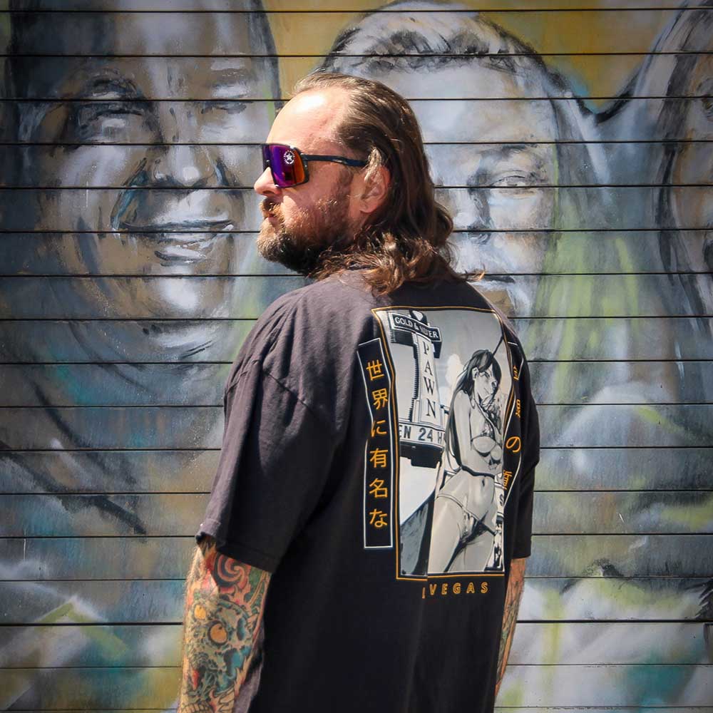 Chumlee wearing a Gold & Silver Pawn anime girl shirt in front of the "Pawn Stars" mural