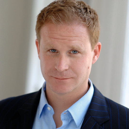 A picture of a man in a blue suit with short red hair